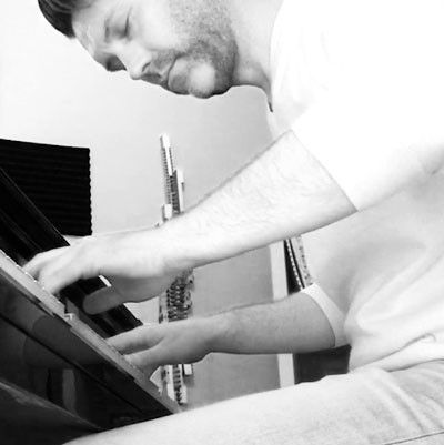 Kyle Mac playing his grand piano